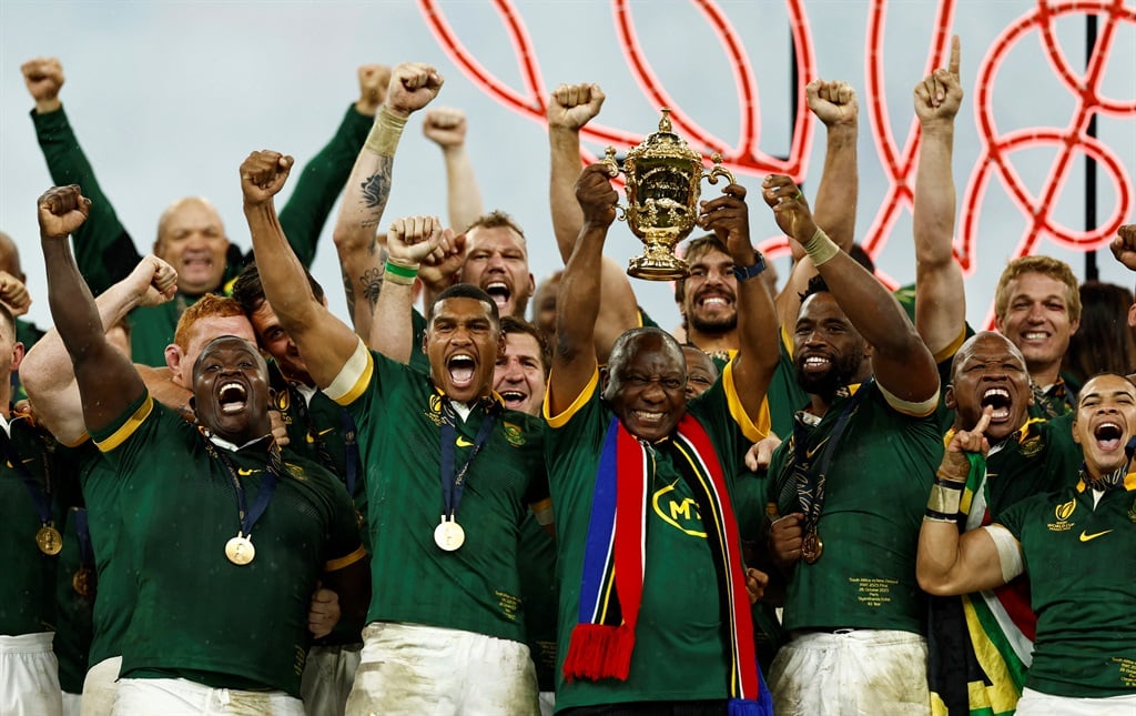President Cyril Ramaphosa lifts The Webb Ellis Cup as South Africa celebrate winning the world cup final.
